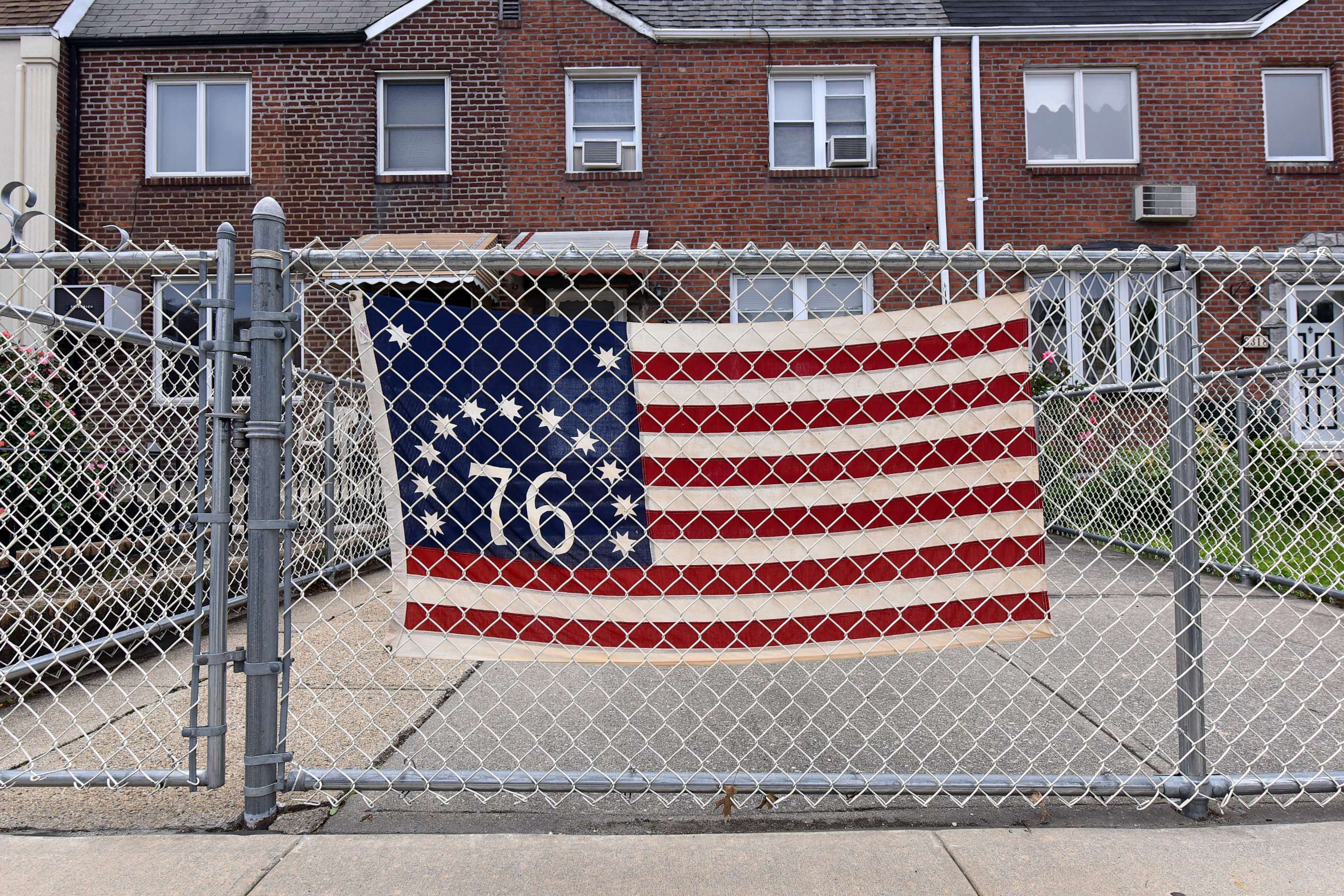 PHOTO: A US bicentenial flag hangs from fence outside a home during Memorial Day in the Queens borough of New York City, May 25, 2020.