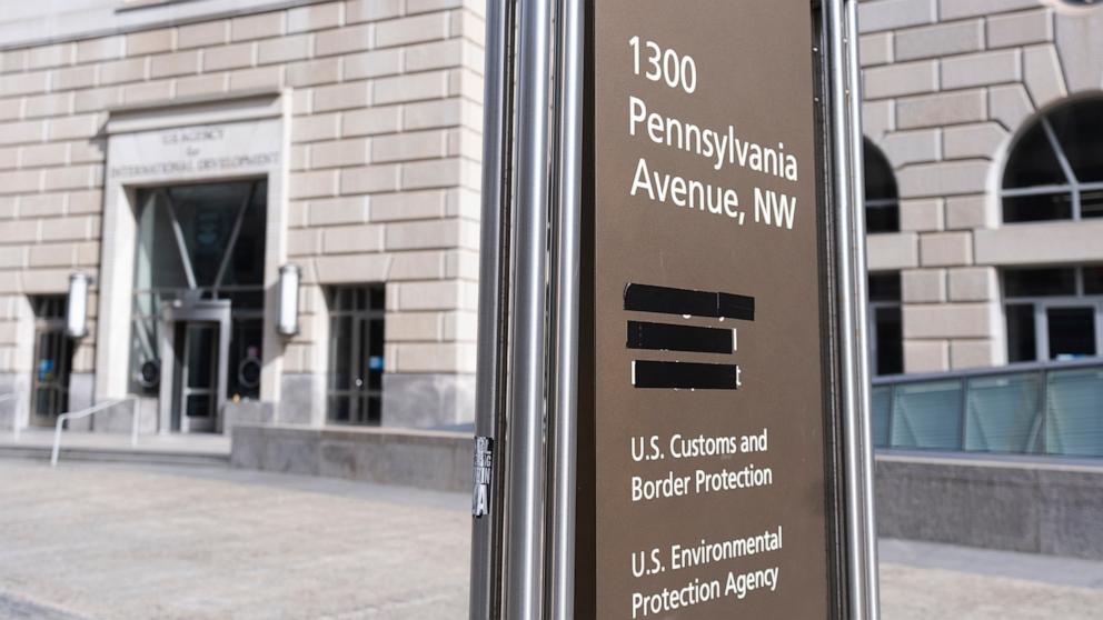 PHOTO: A street sign with names of U.S. government agencies housed at the Ronald Reagan Building is pictured with one building occupant taped, on Feb. 7, 2025, in Washington, D.C.