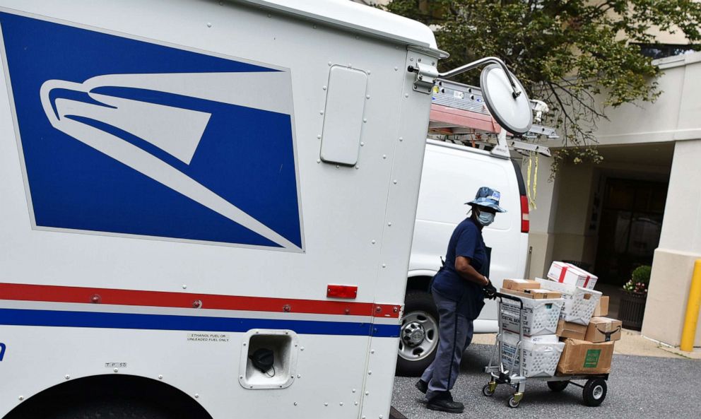 PHOTO: A mail carrier delivers mail to an apartment building in Bethesda, Md. on Aug. 21, 2020.