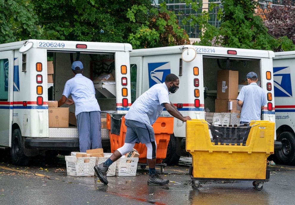 PHOTO: In this July 31, 2020, file photo, letter carriers load mail trucks for deliveries at a U.S. Postal Service facility in McLean, Va.