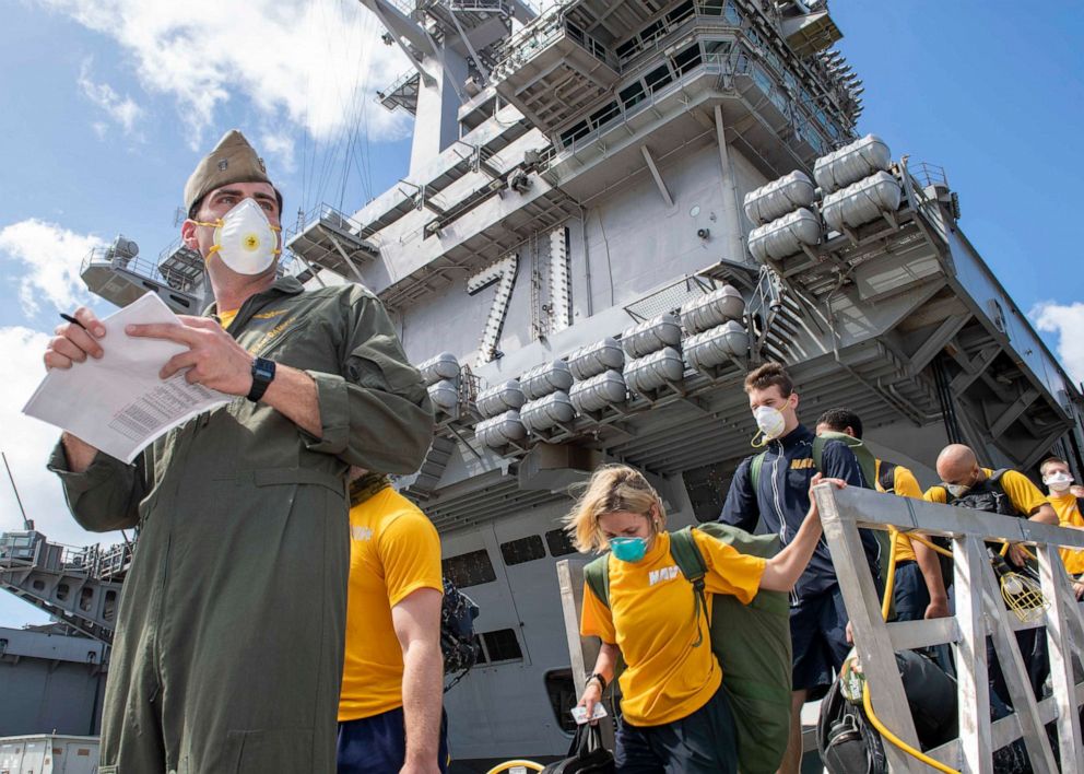 PHOTO: Sailors assigned to the aircraft carrier USS Theodore Roosevelt (CVN 71) depart the ship to move to off-ship berthing, April 10, 2020. 