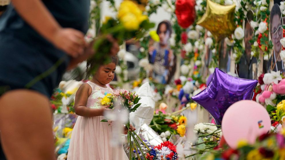 PHOTO: A young visitor brings flowers to a memorial as for the victims killed in last week's Robb Elementary School shooting, May 31, 2022, in Uvalde, Texas.