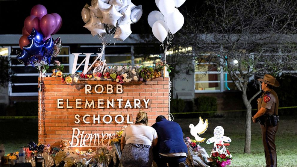 PHOTO:  Stephanie and Michael Chavez of San Antonio pay their respects at a makeshift memorial outside Robb Elementary School, the site of a mass shooting, in Uvalde, Texas, May 25, 2022. 