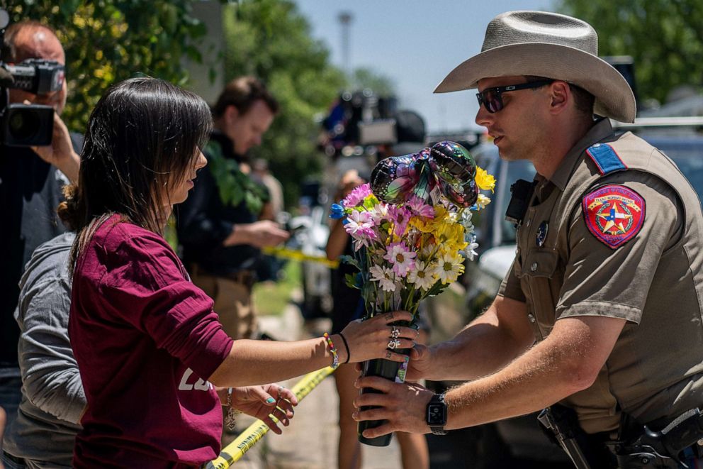 PHOTO: community member Amanda Welch brings flowers to lay at Robb Elementary School on May 25, 2022 in Uvalde, Texas.