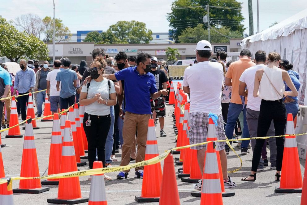 PHOTO: People wait in line to receive a COVID-19 vaccine at a FEMA vaccination center at Miami Dade College, April 5, 2021, in Miami.