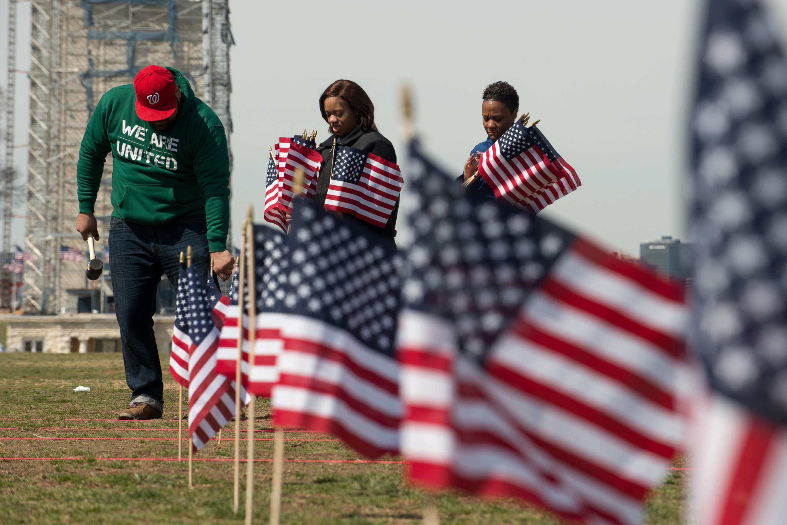 PHOTO: People place American flags on the National Mall in Washington to raise awareness of veterans and service members who died by suicide, March 27, 2014.