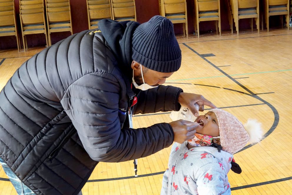 PHOTO: Samuel Cravens helps his three-year-old daughter Azariah with a COVID-19 test at a test site run by CORE at St. Benedict the African Catholic Church in the Englewood neighborhood of Chicago, Nov. 12, 2020.