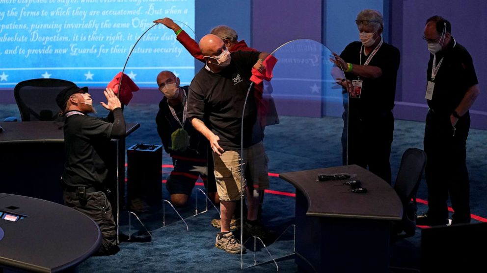 PHOTO: Workers clean protective plastic panels onstage between tables for Vice President Mike Pence and Sen. Kamala Harris as preparations take place for the vice presidential debate at the University of Utah, Oct. 6, 2020, in Salt Lake City.