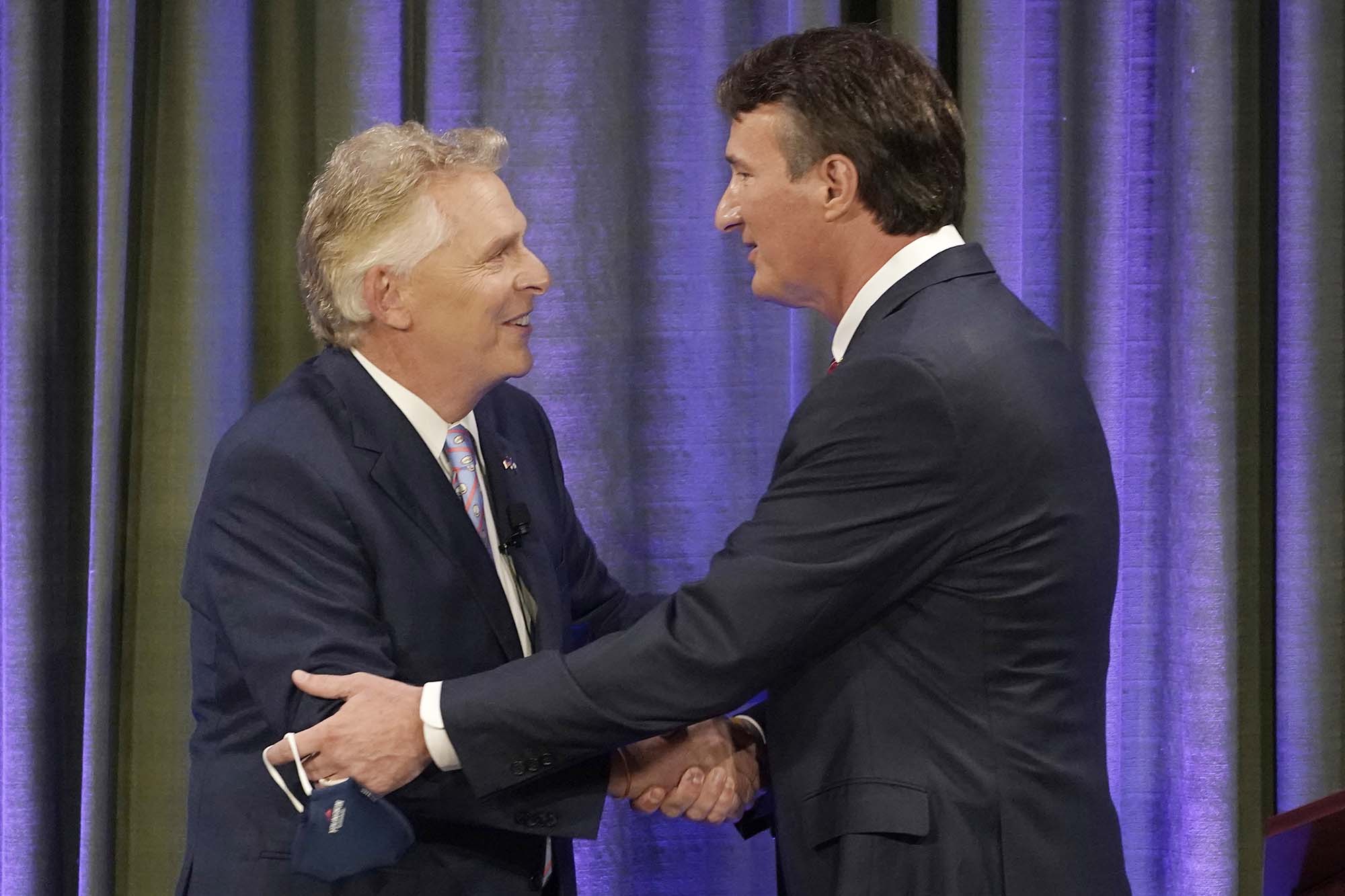 PHOTO: Democratic gubernatorial candidate former Governor Terry McAuliffe, left, greets Republican challenger, Glenn Youngkin, at the start of a debate at the Appalachian School of Law in Grundy, Va., Sept. 16, 2021. 