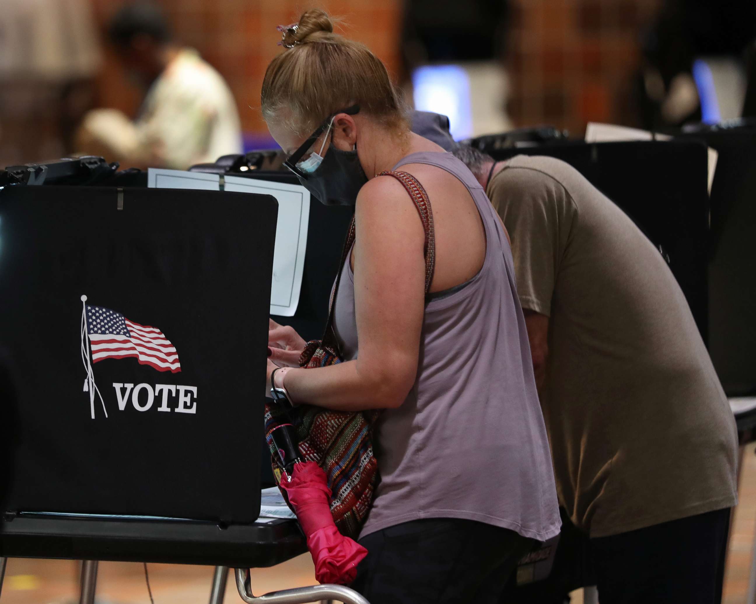 PHOTO: Voters fill out their ballots as they vote at the Stephen P. Clark Government Center polling station, Oct. 21, 2020, in Miami.