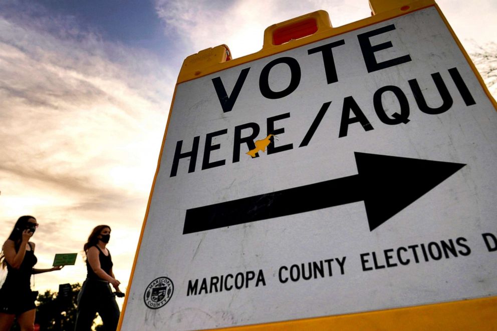 PHOTO: In this Nov. 3, 2020, file photo, voters deliver their ballot to a polling station in Tempe, Ariz.