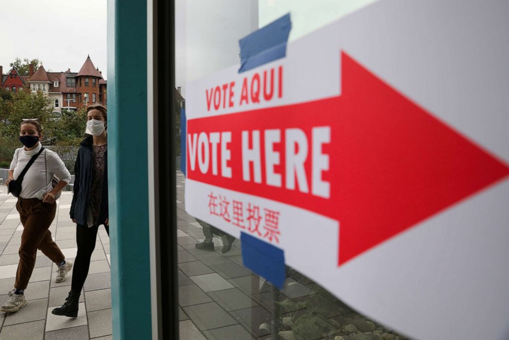 PHOTO: People walk into a voting station to cast their ballot by early vote at the Marie Reed Elementary School in the Adams Morgan Neighborhood in Washington on Oct. 28, 2020.