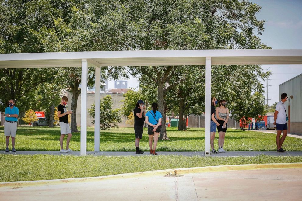 PHOTO: Voters keep their distance from others in line while waiting to to vote in the runoff election Tuesday, July 14, 2020, in Houston.