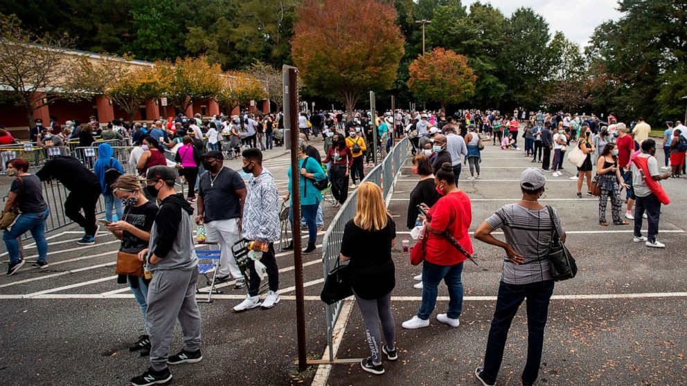PHOTO: Hundreds of people wait in line for early voting in Marietta, Ga., Oct. 12, 2020. 