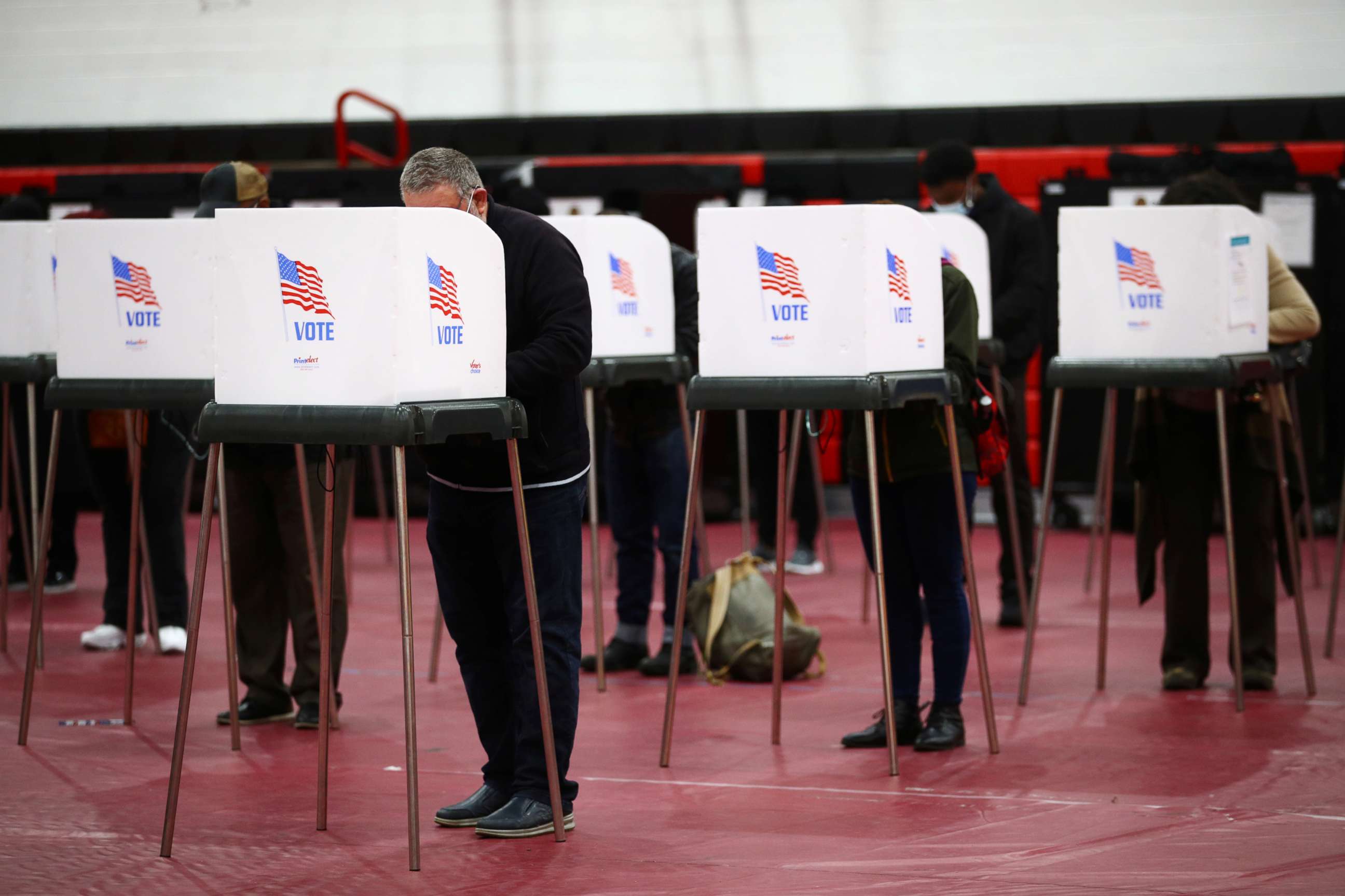 PHOTO: People fill out ballots in privacy booths at a polling station located in the Baltimore City Community College gymnasium in Baltimore, during early voting in Maryland, Oct. 26, 2020.