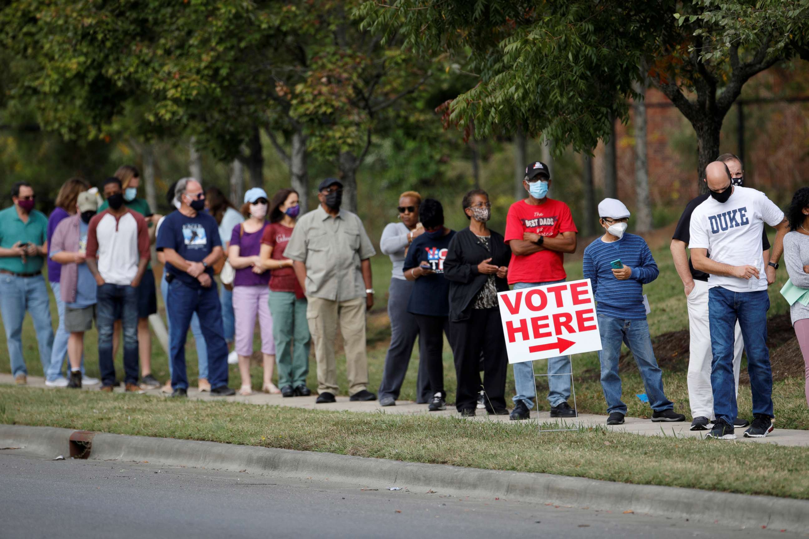 PHOTO: In this Oct. 15, 2020, file photo, voters wait in line to enter a polling place and cast their ballots on the first day of the state's in-person early voting for the general elections in Durham, N.C.