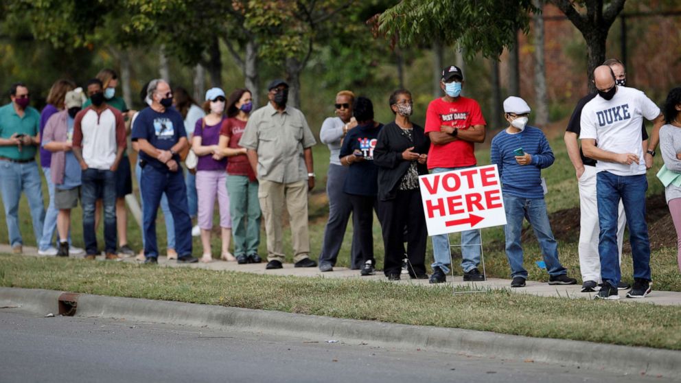 PHOTO: In this Oct. 15, 2020, file photo, voters wait in line to enter a polling place and cast their ballots on the first day of the state's in-person early voting for the general elections in Durham, N.C.