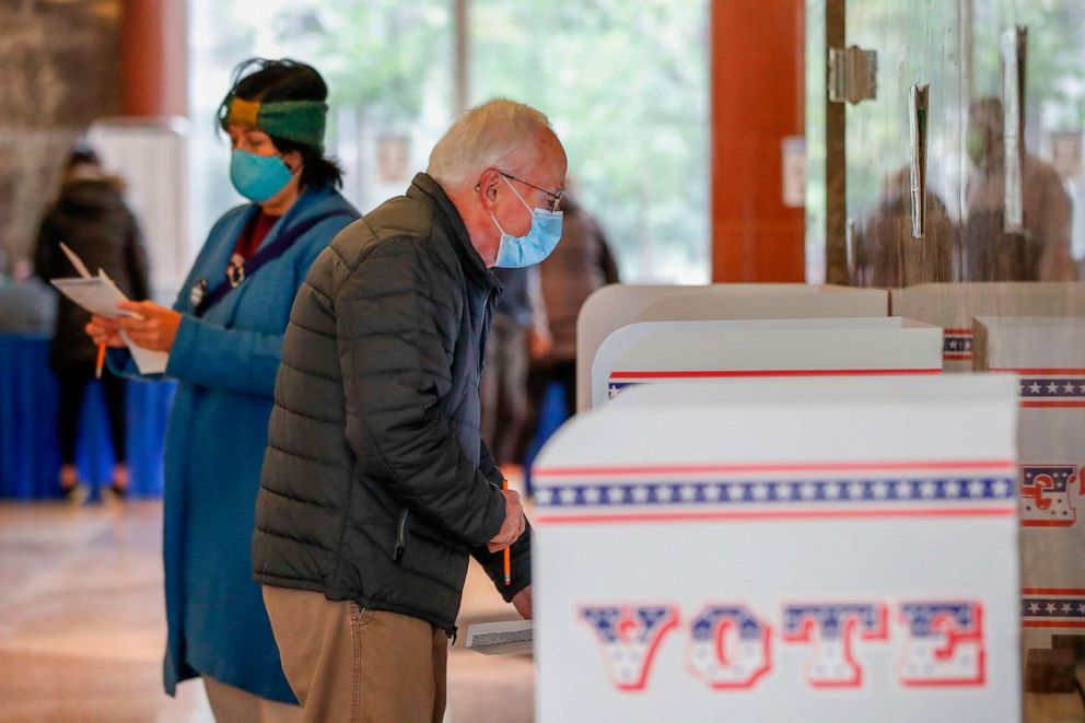 PHOTO: A man casts his ballot at the Frank P. Zeidler Municipal Building on the first day of in-person early voting for the Nov. 3, 2020, elections in Milwaukee, Wis., Oct. 20, 2020.