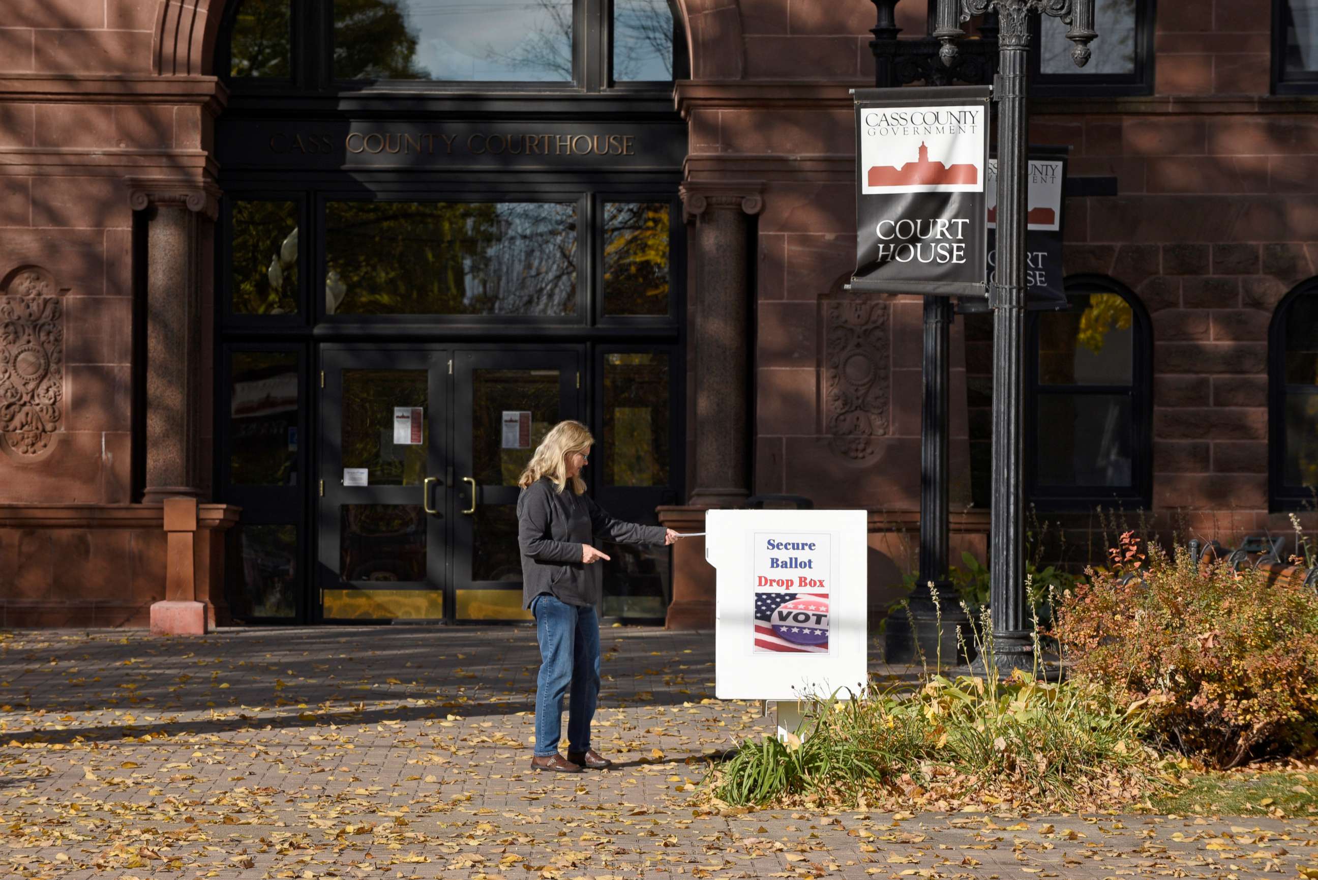 PHOTO: A voter places a ballot for the 2020 Presidential elections in a drop box outside the Cass County Courthouse in Fargo, North Dakota, Oct. 15, 2020.