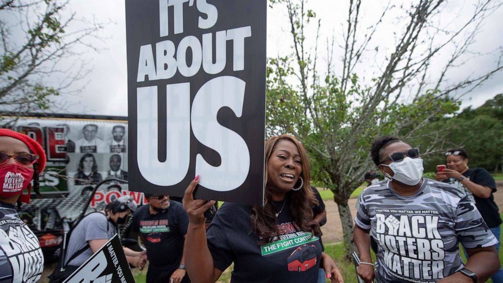 PHOTO: LaTosha Brown holds a sign during the launch of the Freedom Ride for Voting Rights Bus Tour on Juneteenth in Jackson, Mississippi, on June 19, 2021.