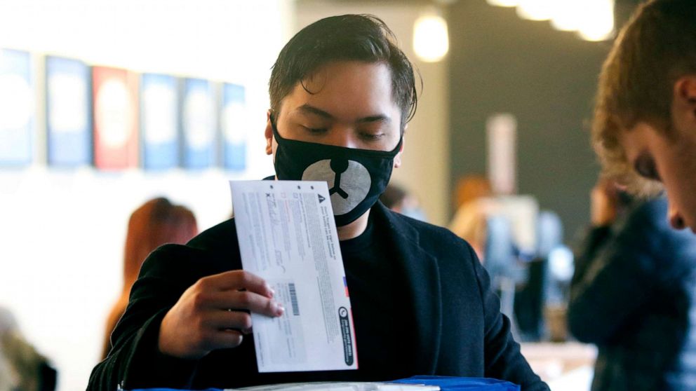 PHOTO: Matthew Guerrero, 22, of Des Moines, Washington wears a bear mask as he drops off his presidential primary mail-in ballot in person at King County Elections in Renton, Washington, March 10, 2020.