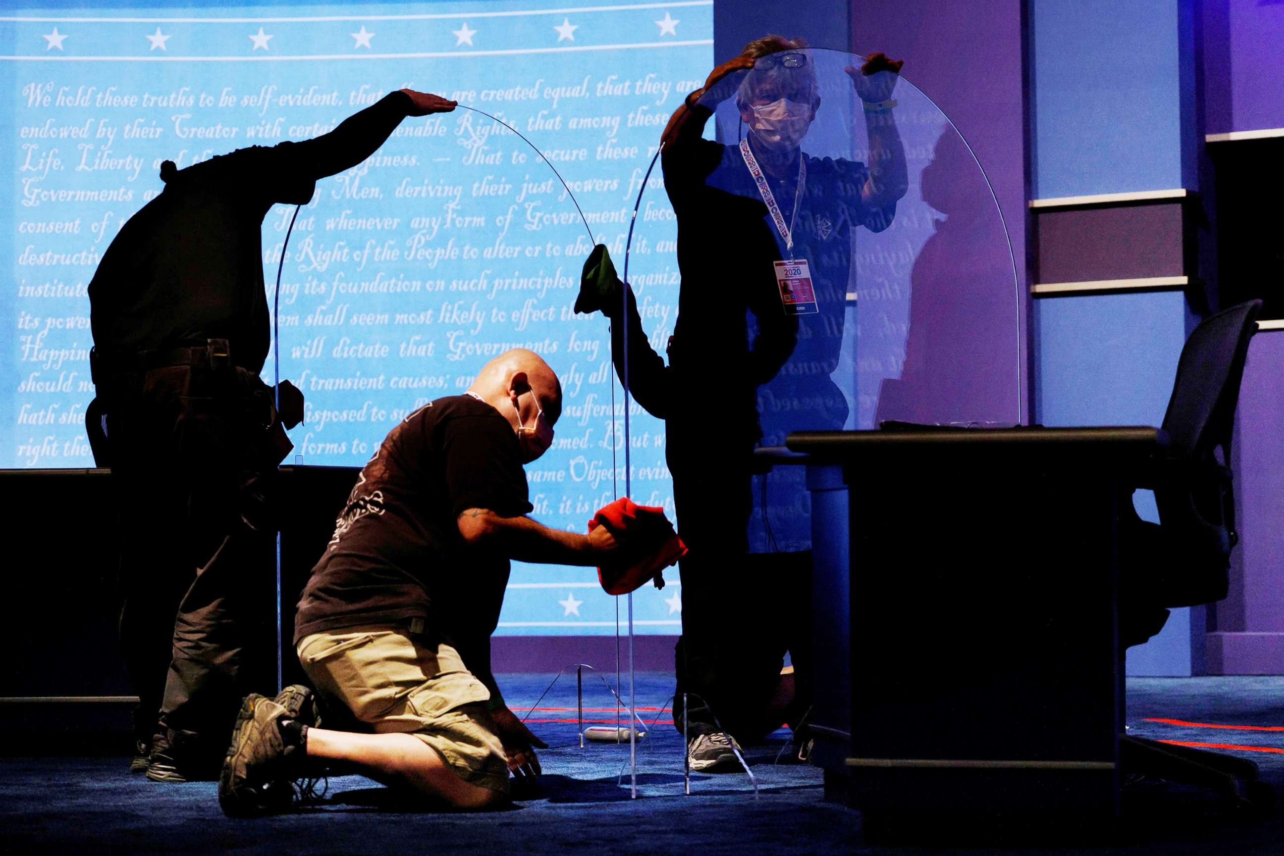 PHOTO: Commission on Presidential Debates staff clean the freshly installed protective plexiglass panels between the candidates' seats for the 2020 vice presidential debate on the campus of the University of Utah in Salt Lake City, Utah, Oct. 6, 2020.