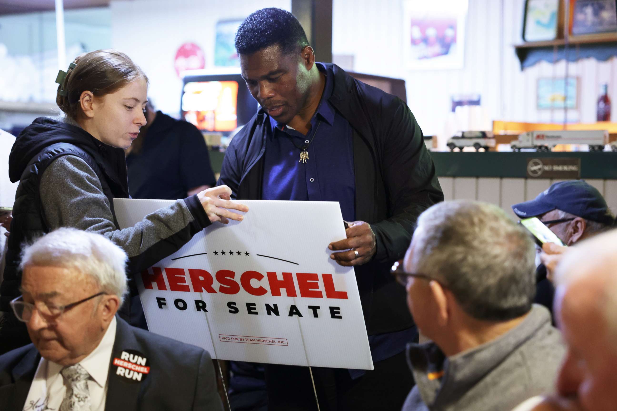 PHOTO: Georgia Republican senate candidate Herschel Walker signs autograph for a supporter during a campaign stop, Dec. 5, 2022, in Flowery Branch, Georgia.