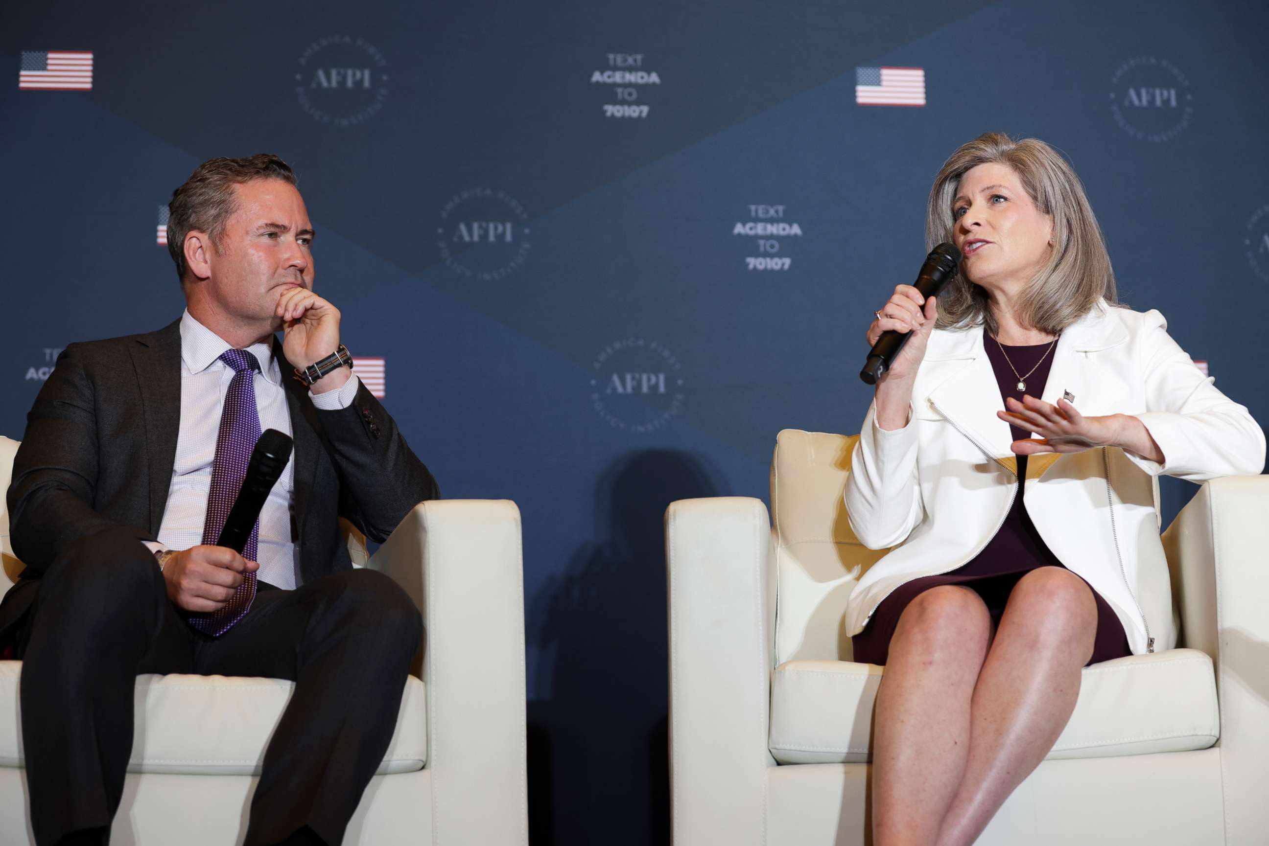 PHOTO: Sen. Joni Ernst speaks, as Rep. Michael Waltz left, listens, during the America First Agenda Summit organized by America First Policy Institute AFPI, on July 25, 2022 in Washington, DC.