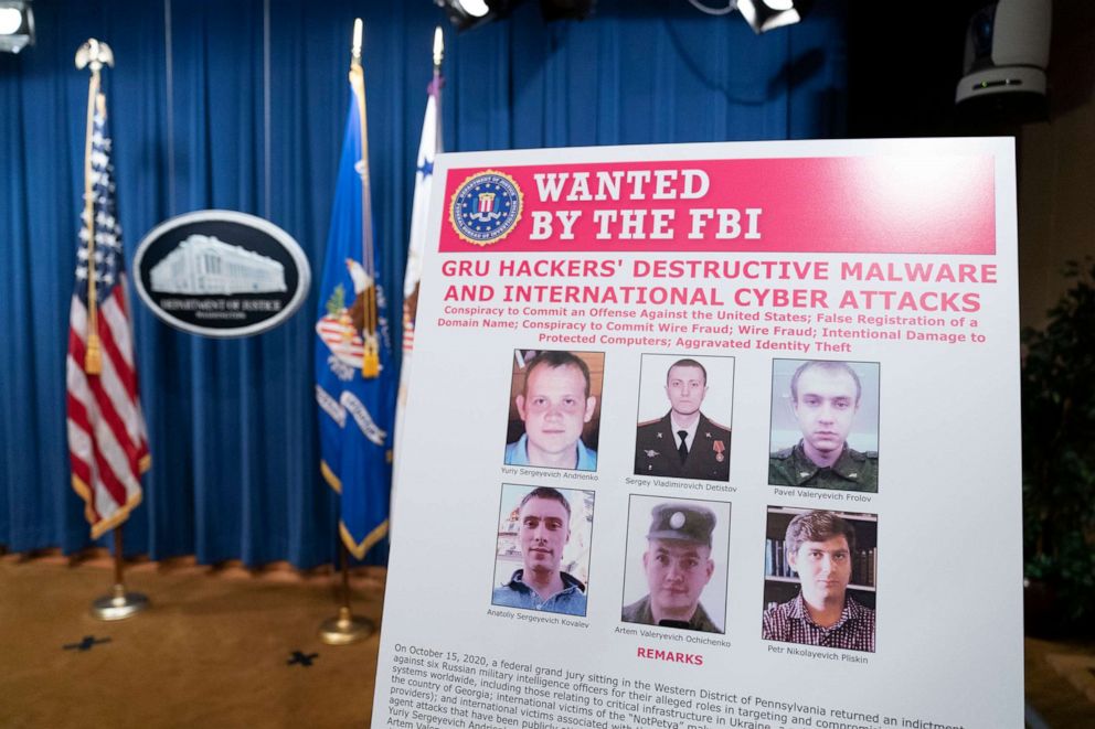 PHOTO: A poster showing six wanted Russian military intelligence officers is displayed before a news conference at the Department of Justice, on Oct. 19, 2020 in Washington, DC.