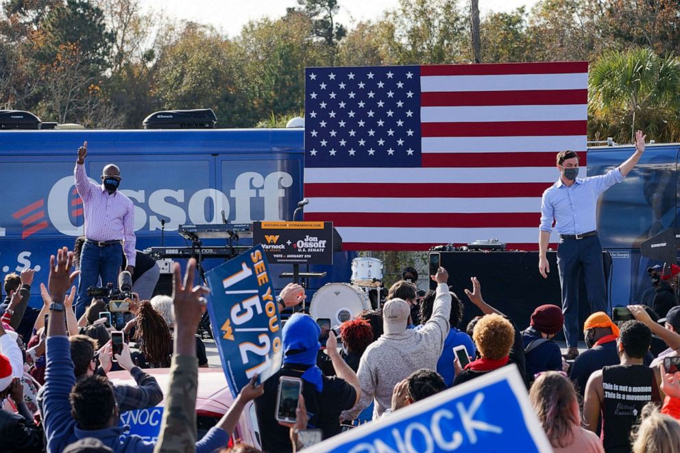 PHOTO: Democratic Senate candidates Jon Ossoff and Rev. Raphael Warnock speak to a group of supporters at a rally on Dec. 19, 2020, in Savannah, Ga.