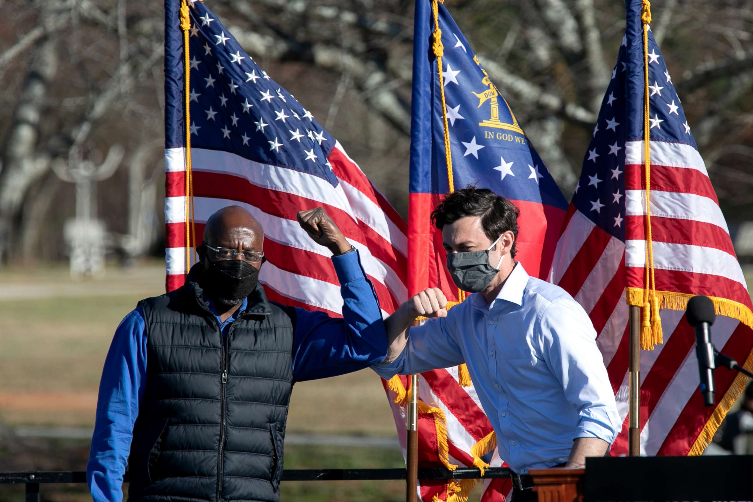 PHOTO: Democratic Senate candidates Raphael Warnock, left, and Jon Ossoff bump elbows during an outdoor drive-in rally, Dec. 5, 2020 in Conyers, Georgia.