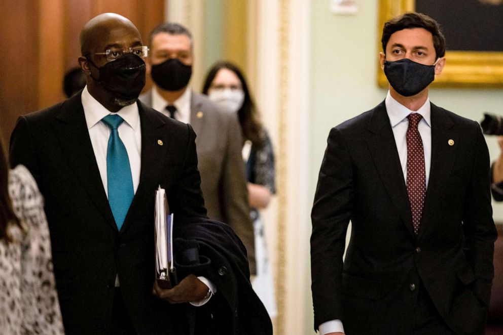 PHOTO: Senators Raphael Warnock, left, and Jon Ossoff head to a photo op with other new Democratic Senators on Capitol Hill in Washington, DC, Jan. 21, 2021.