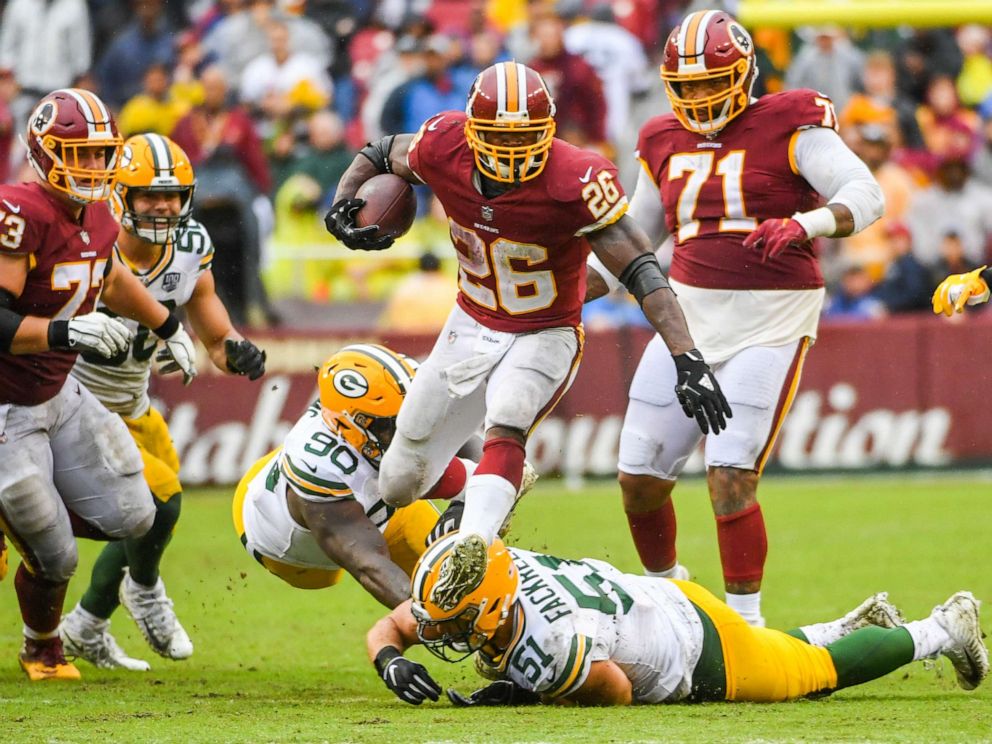 PHOTO: Washington Redskins running back Adrian Peterson leaps over Green Bay Packers linebacker Kyler Fackrell for a big fourth quarter gain at  FedEx Field.
