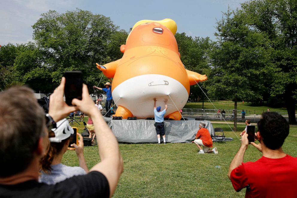 PHOTO: People photograph a Baby Trump balloon as it is moved into position before Independence Day celebrations, July 4, 2019, on the National Mall in Washington.