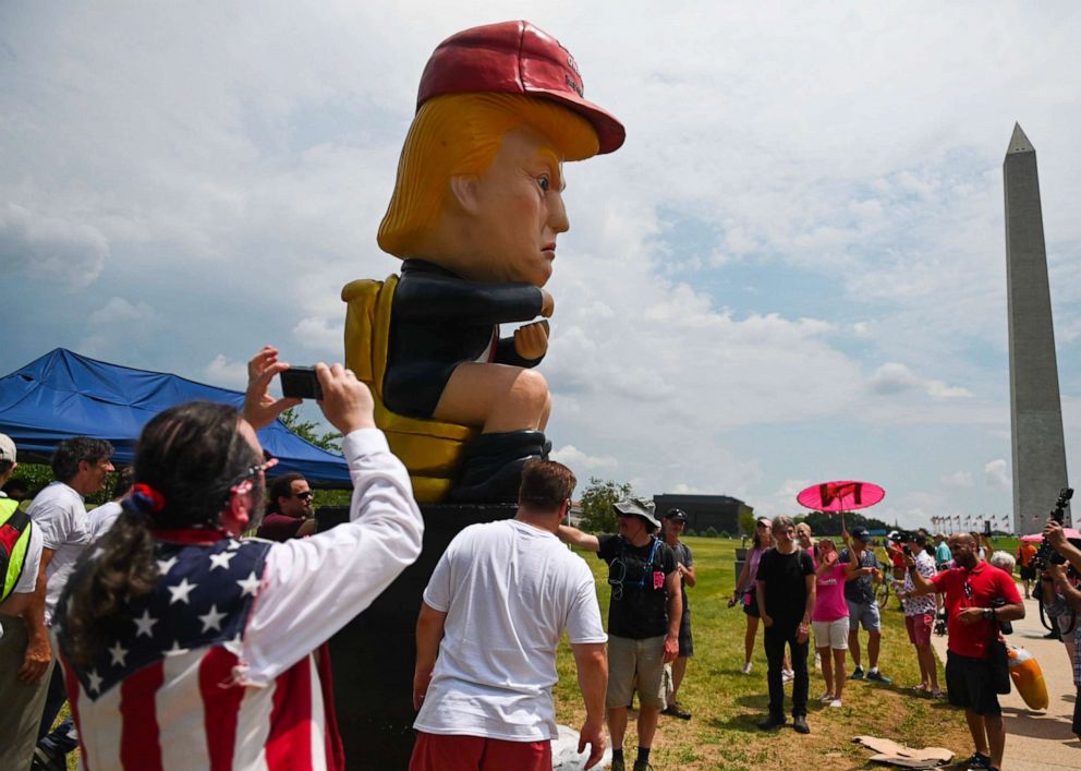 PHOTO: People take photos of a statue of President Donald Trump tweeting on a toilet, at the National Mall ahead of the, "Salute to America" Fourth of July event in Washington, July 4, 2019.