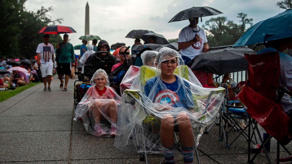 PHOTO: People cover from the rain as they gather on the National Mall ahead of the "Salute to America" Fourth of July event with President Donald Trump at the Lincoln Memorial in Washington, July 4, 2019.