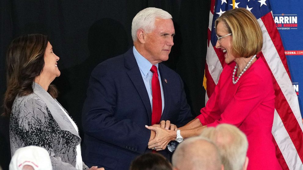 PHOTO: Former Vice President Mike Pence and his wife Karen Pence shake hands with gubernatorial candidate Karrin Taylor Robson during her campaign event in Peoria, Ariz, July 22, 2022.