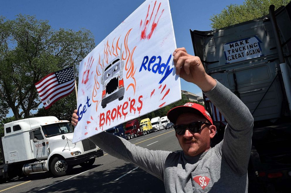 PHOTO: A man holds up a sign as truckers protest low rates and lack of broker transparency during the coronavirus pandemic along Constitution Avenue on May 15, 2020, in Washington.