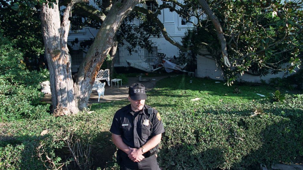 A uniformed Secret Service agent stands guard over the wreckage of a single-engine plane, which rests against the South Portico near the Rose Garden at the White House in Washington, D.C., Sept. 12, 1994.