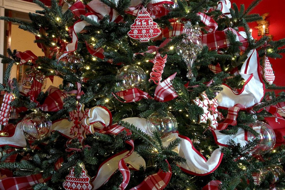 PHOTO: Ornaments are hung on a Christmas tree in the Red Room at the White House during a press preview of the 2017 holiday decorations, Nov. 27, 2017, in Washington.