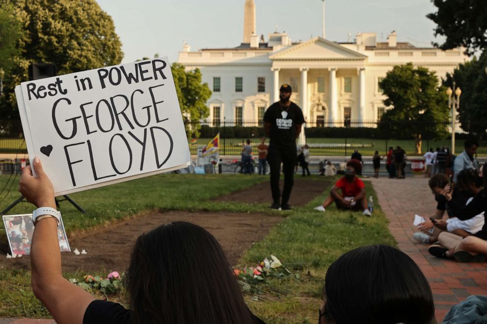 PHOTO: A small group of people gather for a vigil on the one-year anniversary of George Floyd's murder in Lafayette Square near the White House on May 25, 2021, in Washington.