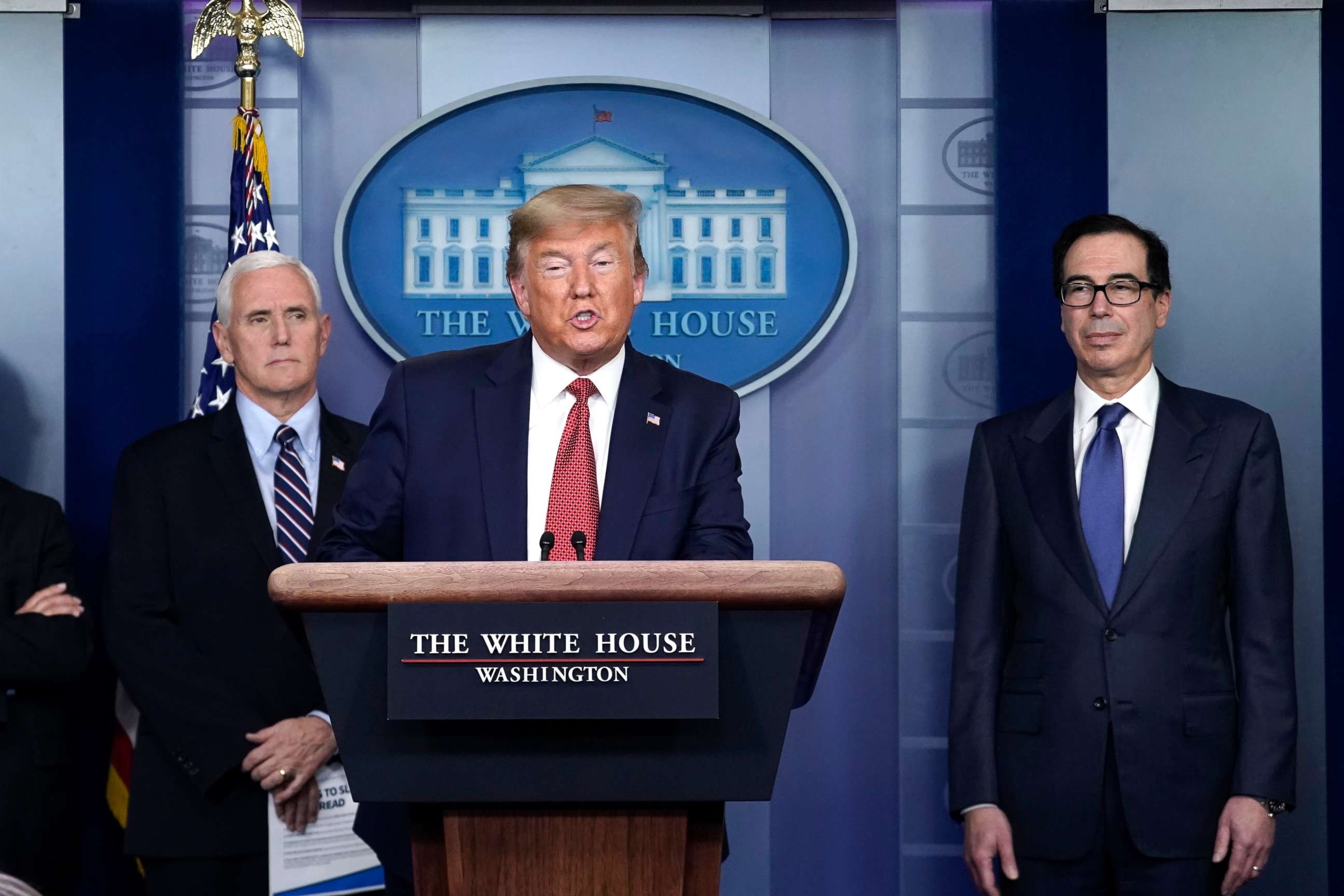 PHOTO: President Donald Trump, joined by Vice President Mike Pence and Secretary of the Treasury Steven Mnuchin, speaks during a briefing on the coronavirus pandemic, in the White House, March 25, 2020, in Washington.