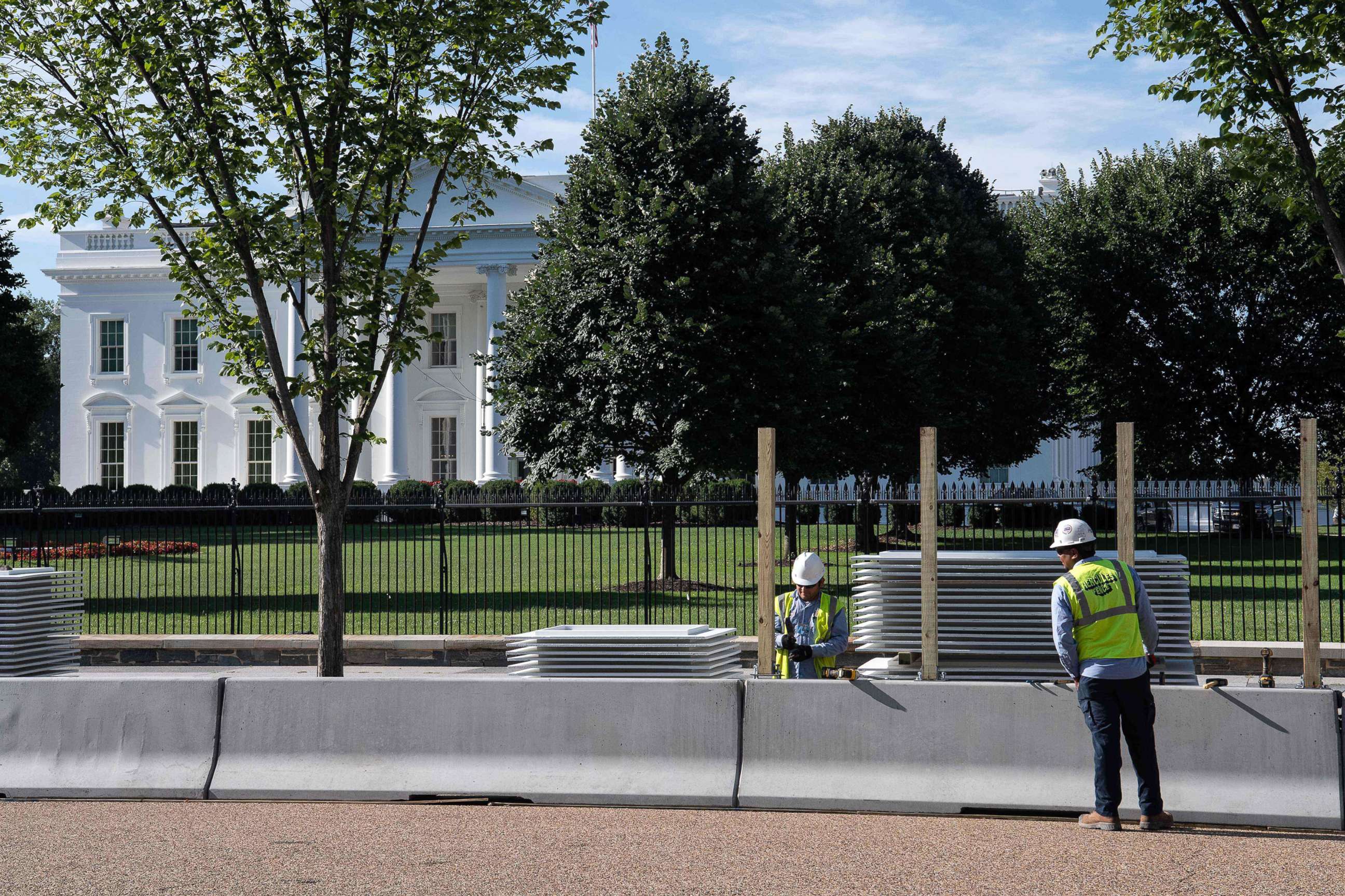PHOTO: Workers construct a protective barrier ahead of a higher fence being erected in front of the White House in Washington, D.C., July 15, 2019.