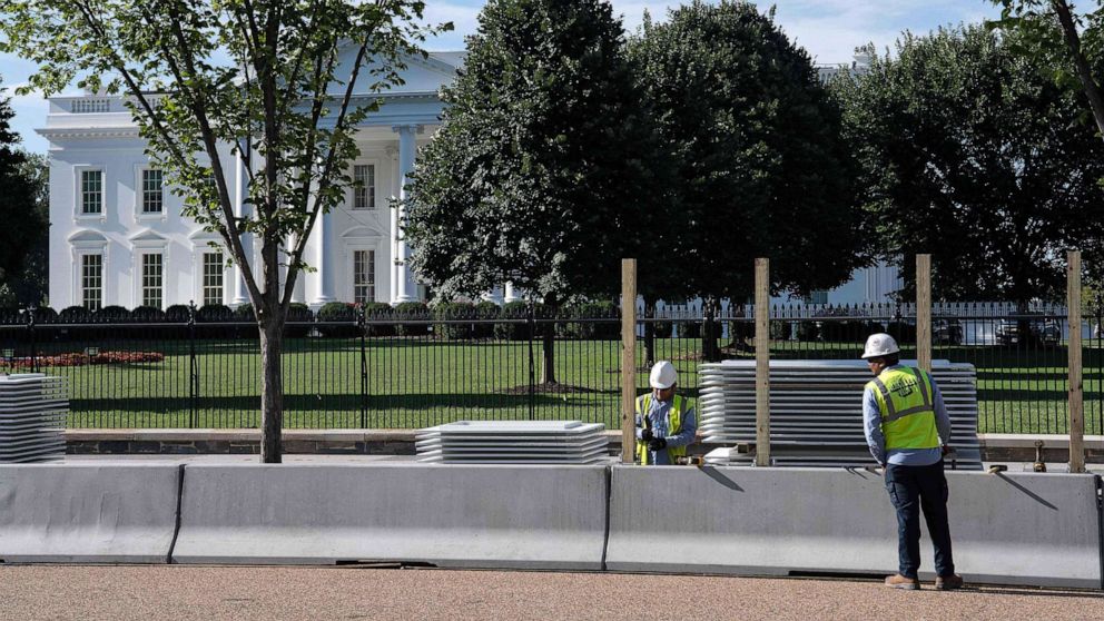 PHOTO: Workers construct a protective barrier ahead of a higher fence being erected in front of the White House in Washington, D.C., July 15, 2019.