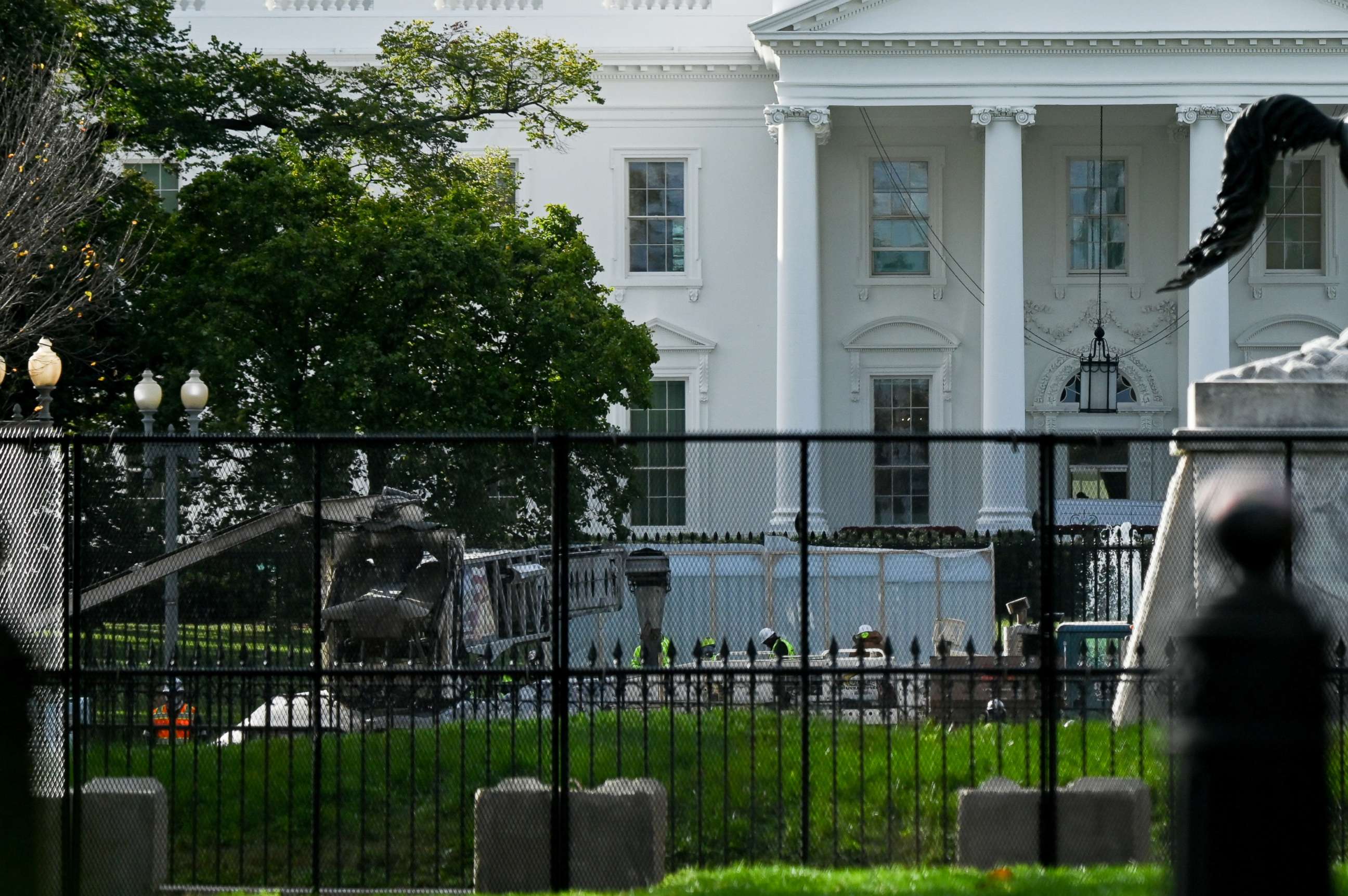 PHOTO: Workers are seen behind layers of security fencing in front of the White House the day before the presidential election in Washington, D.C., Nov. 2, 2020.