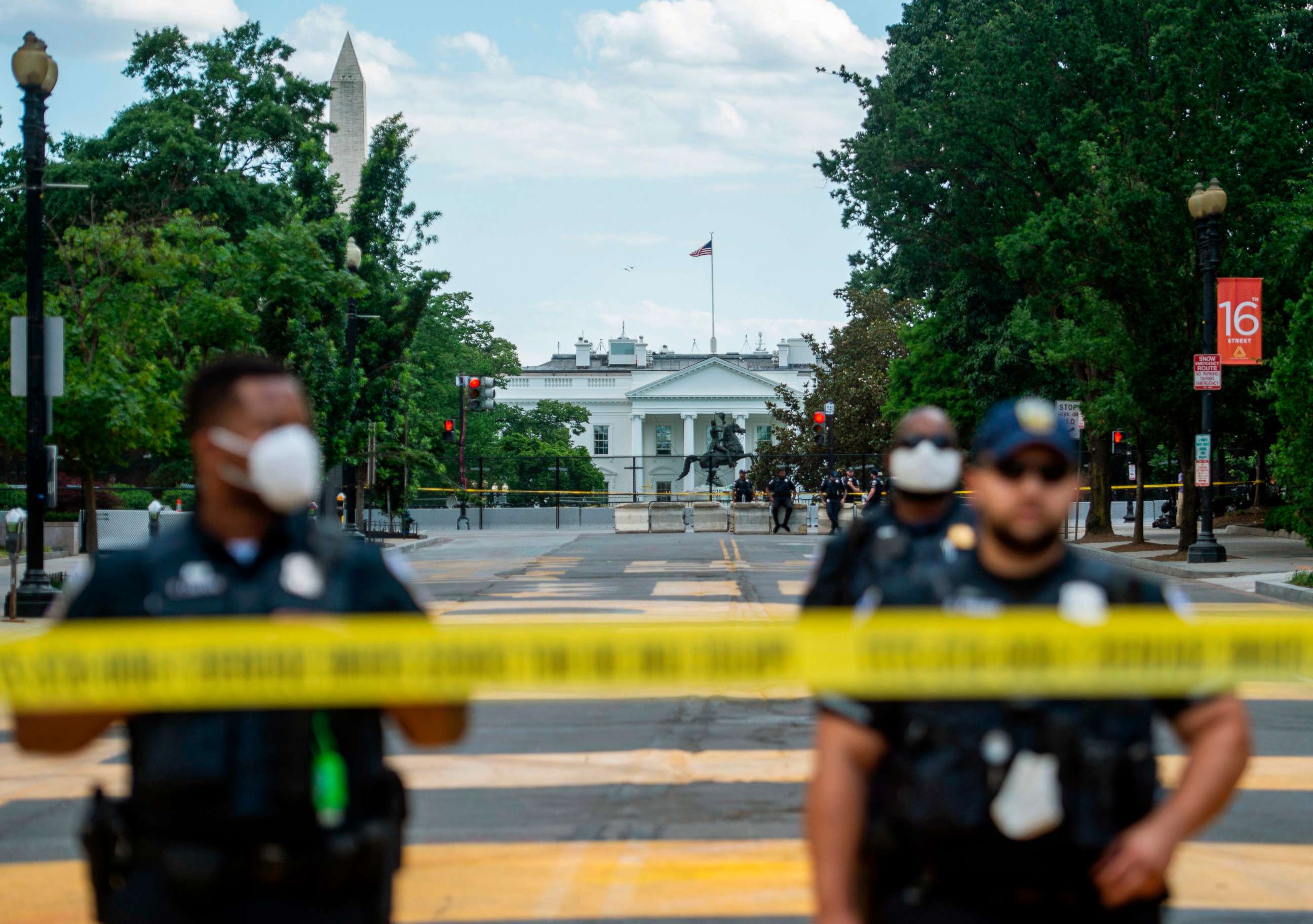 PHOTO: TOPSHOT - Police officers stand behind a police line as they block a road in 'Black Lives Matter' plaza near the White House in Washington, June 24, 2020.