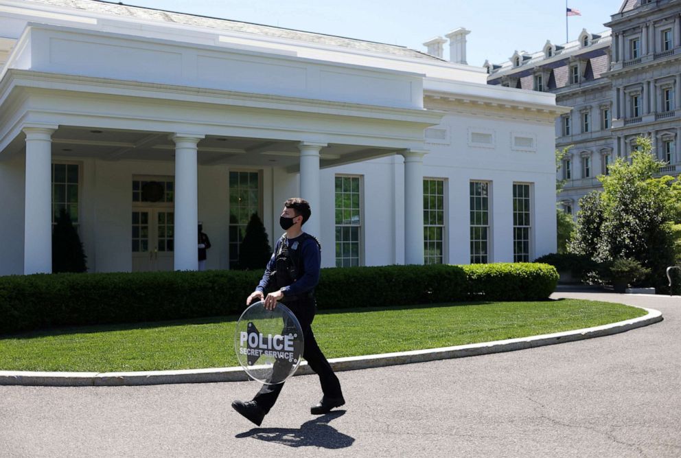 PHOTO: A United States Secret Service Agent carries a riot shield across the West Wing driveway at the White House in Washington, April 20, 2021.