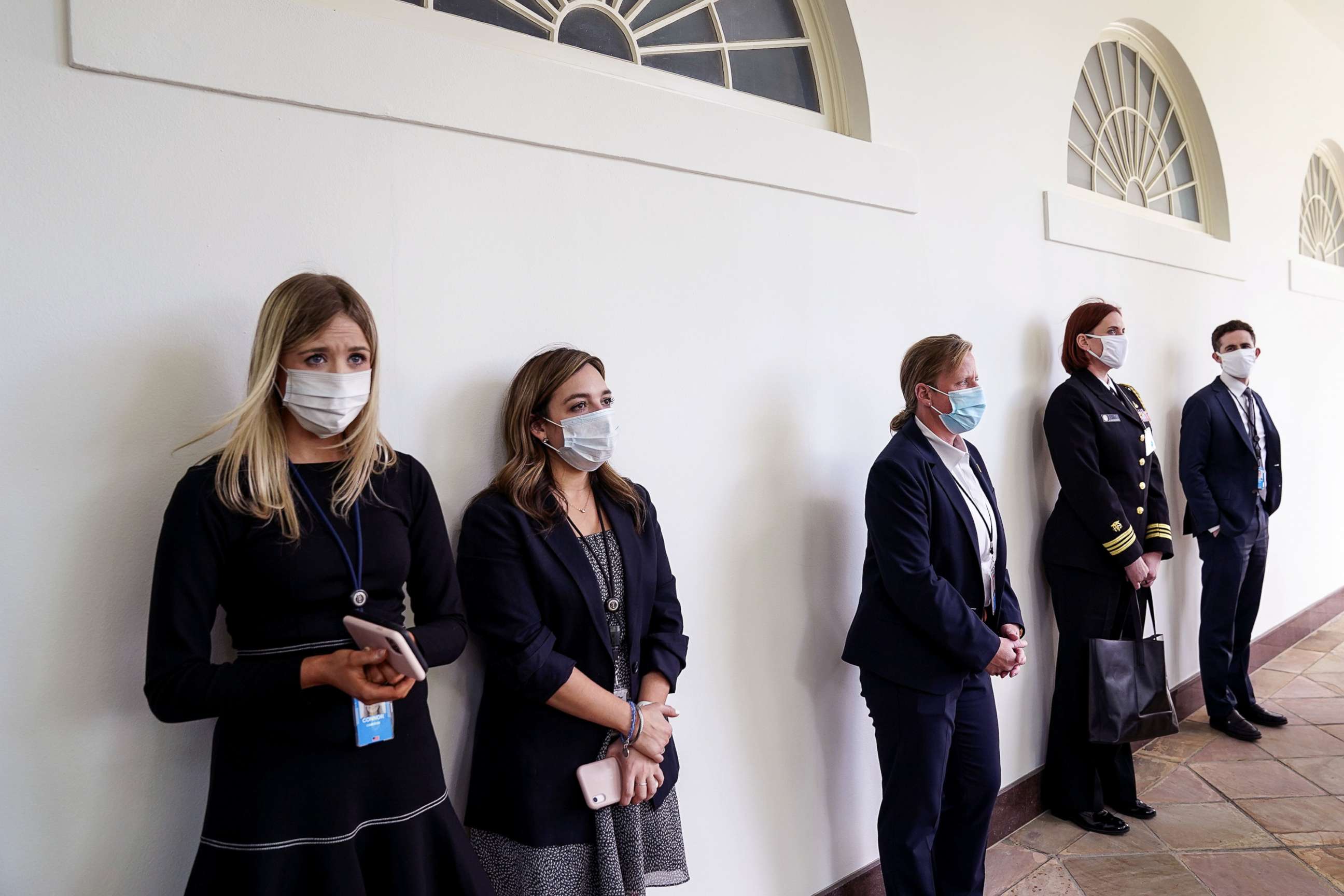 PHOTO: Members of the White House staff and the U.S. Secret Service stand along the West Wing colonnade prior to President Donald Trump holding a coronavirus disease (COVID-19) outbreak press briefing in the Rose Garden at the White House, May 11, 2020.