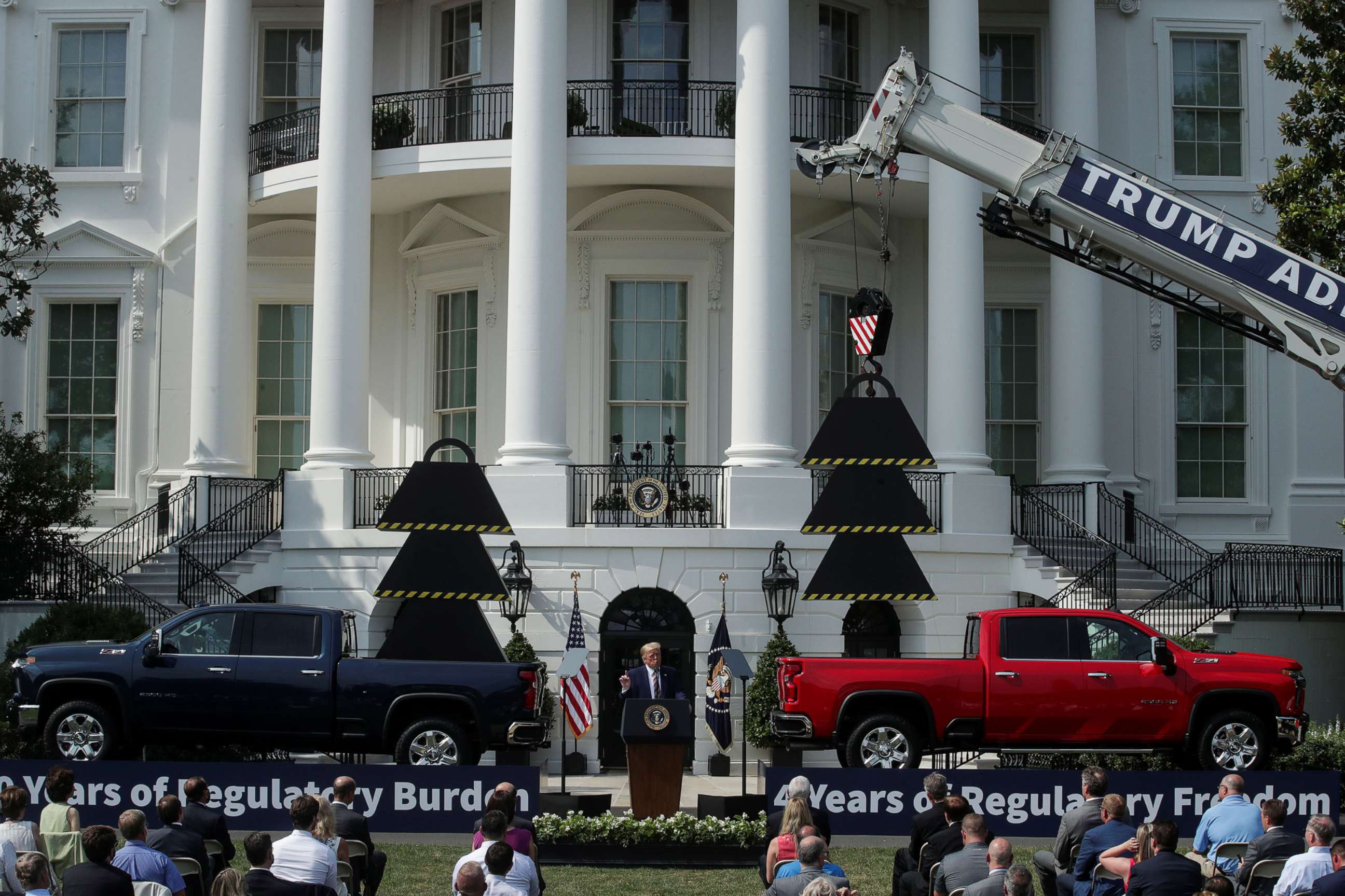 PHOTO: President Donald Trump is flanked by pickup trucks as he speaks about administration efforts to curb federal regulations during an event on the South Lawn of the White House in Washington, July 16, 2020.