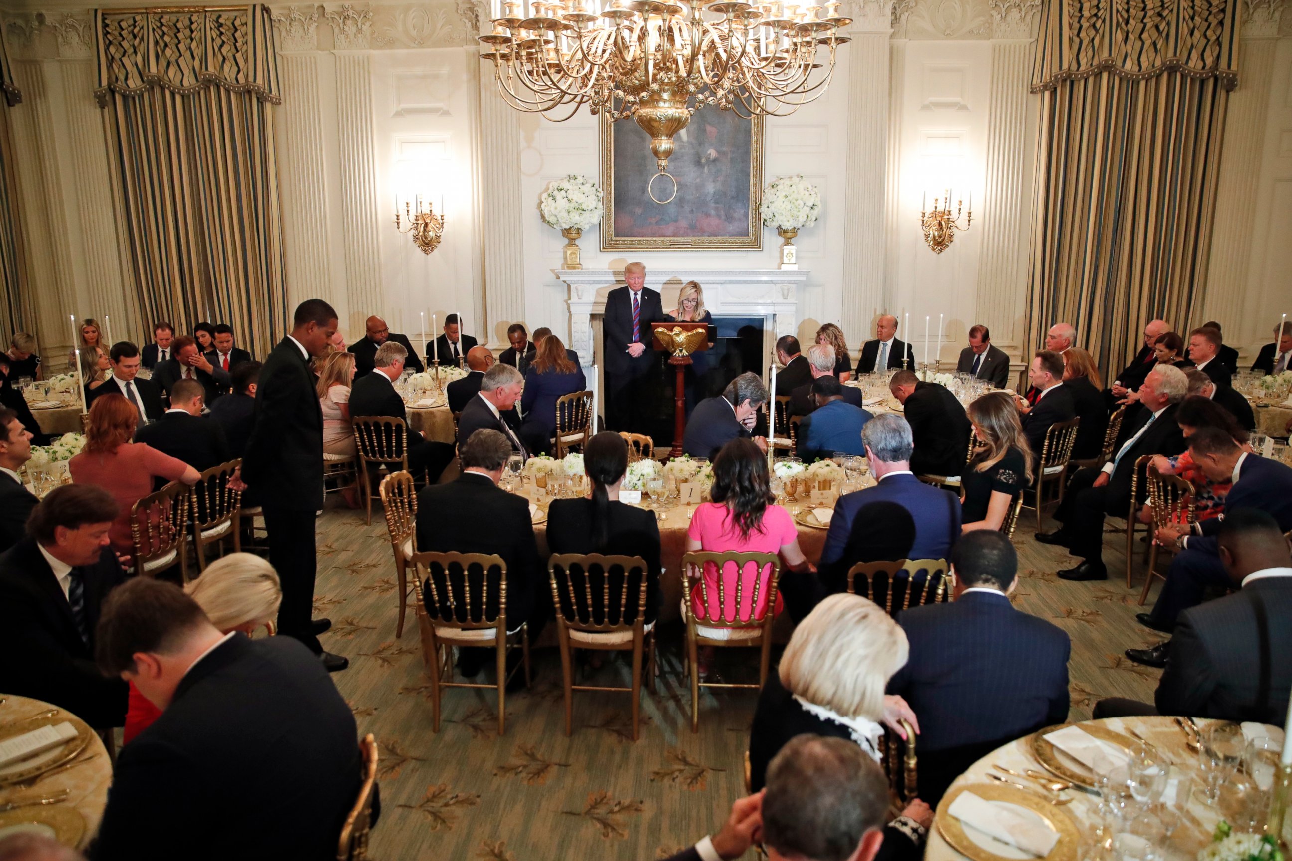PHOTO: President Donald Trump bows his head in prayer as pastor Paula White leads the room in prayer during a dinner for evangelical leaders in the State Dining Room of the White House, Monday, Aug. 27, 2018, in Washington.